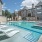spacious swimming pool with ample reclining seats, closeness to property & lush landscaping